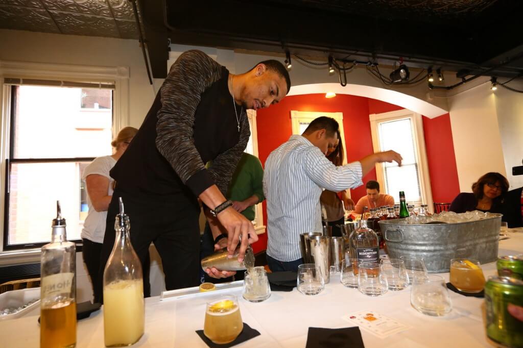 Photograph of Otto Porter Jr. participating in a mixtology class